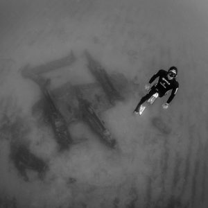 morgan bourc'his remonte à la surface. l'épave du P38 se trouve en arrière plan